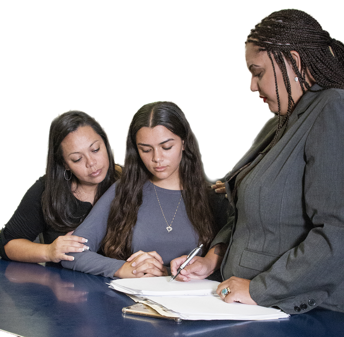Mother and teenage daughter looking a paperwork with female lawyer