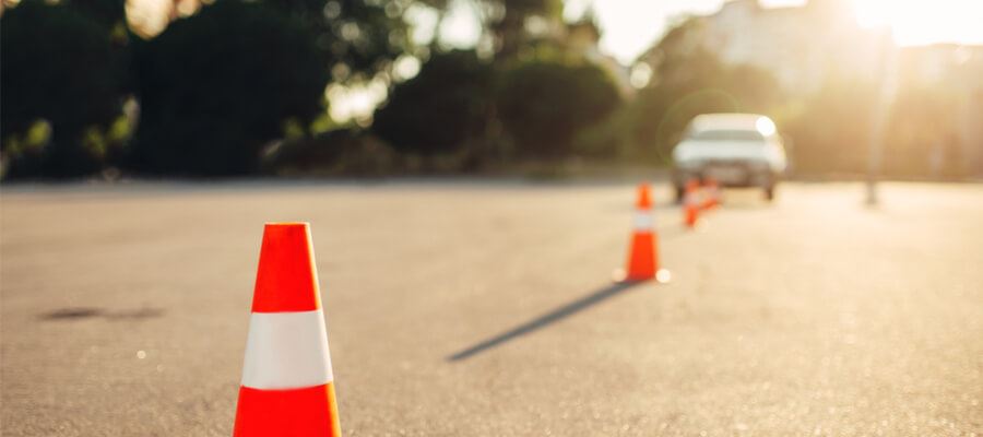 Car parked near roadway safety cones 